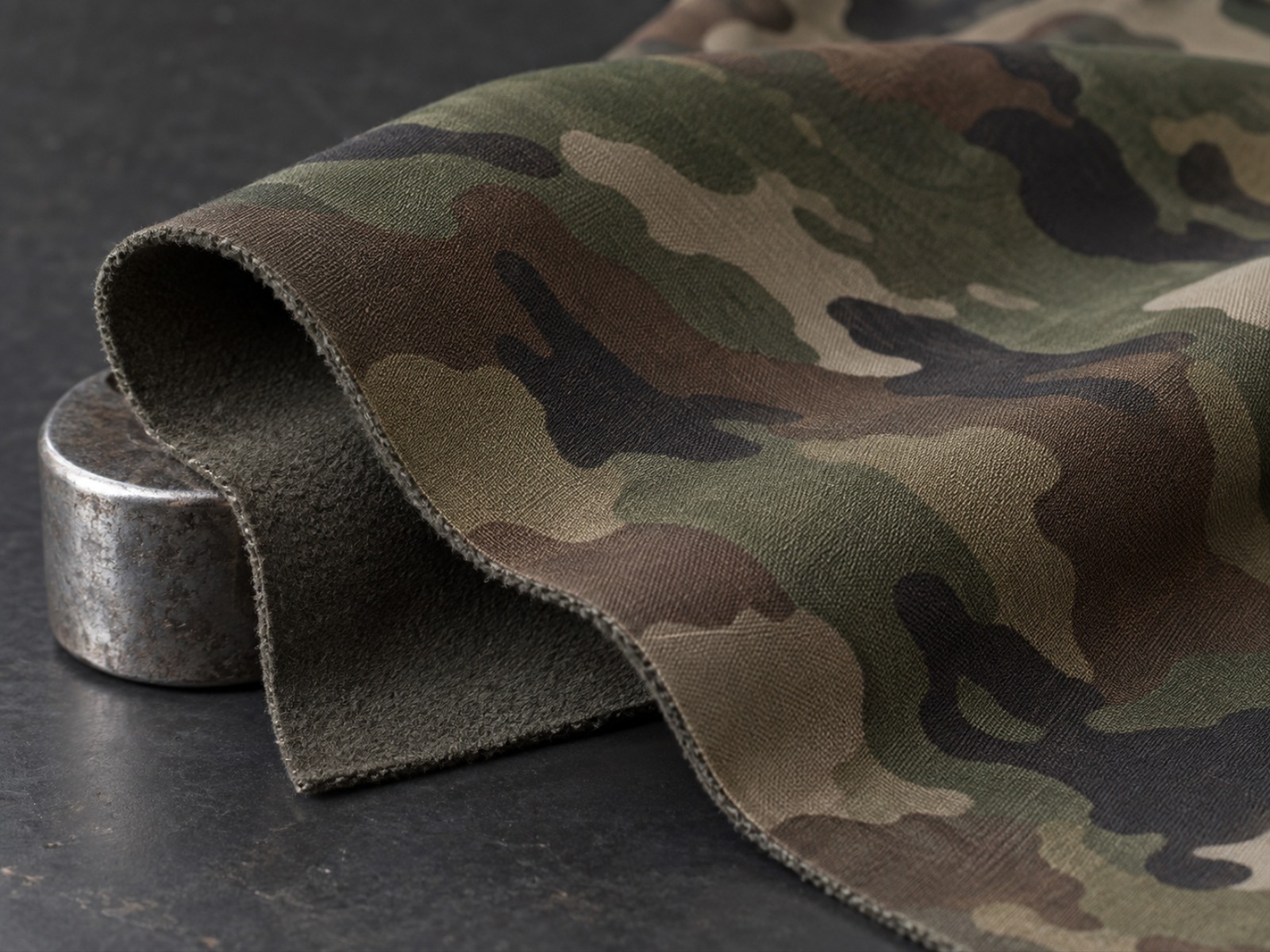 Macro view of softshell fabric showing woven face and knit backing used in tactical softshell jackets