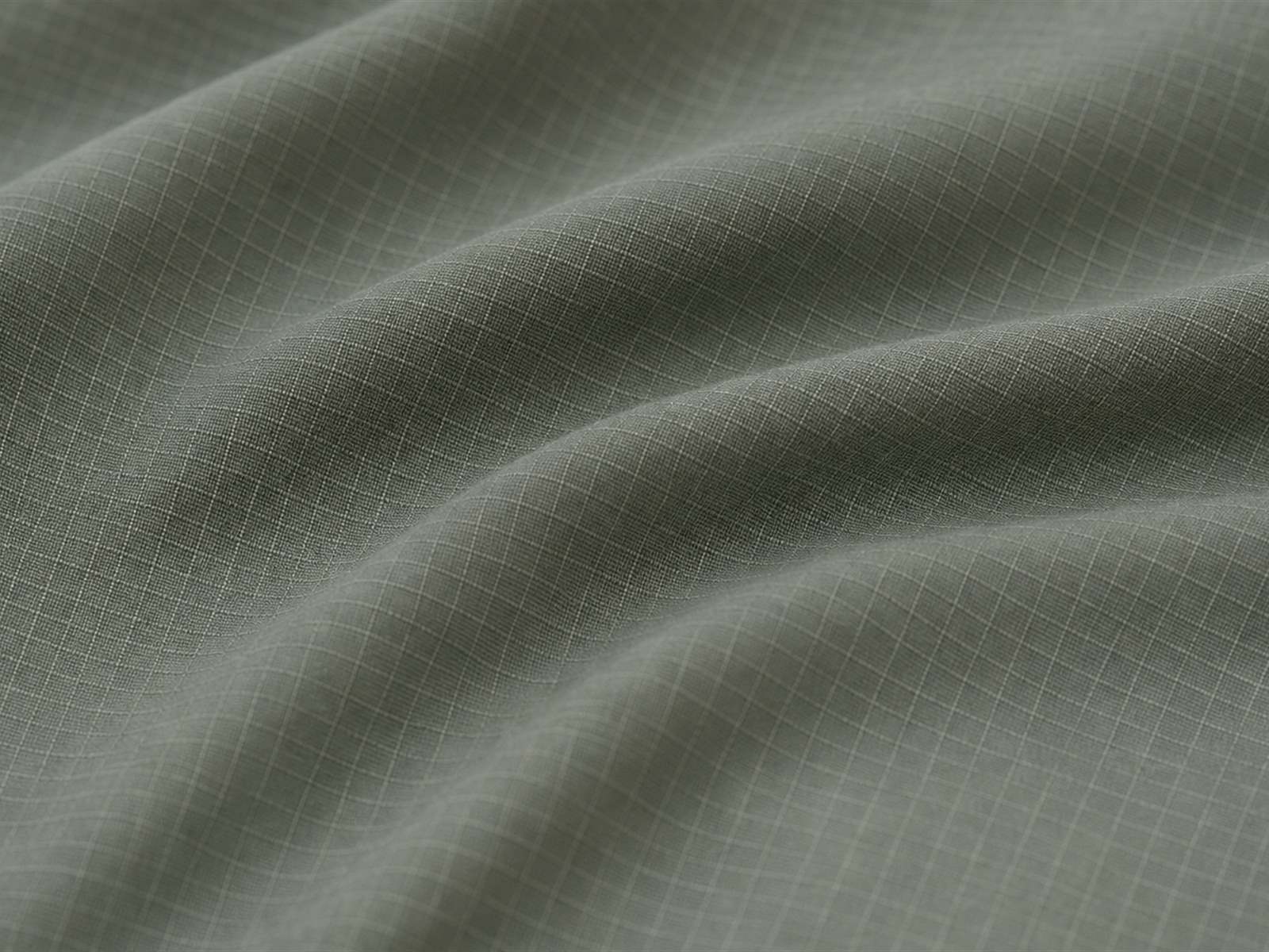 Macro view of stretch ripstop fabric showing ripstop grid combined with stretch yarns for tactical trousers